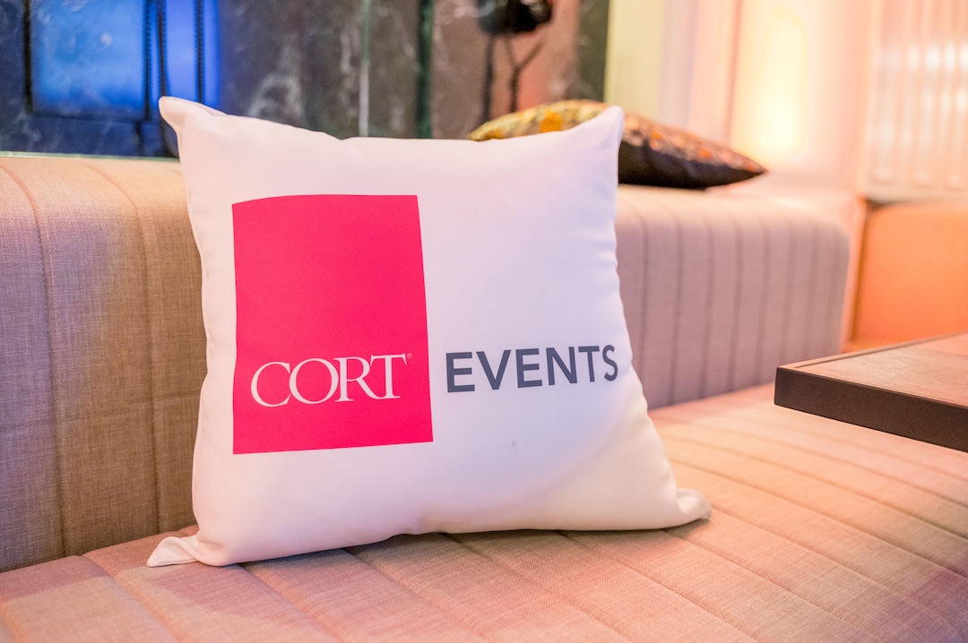 A couch throw pillow branded with CORT events